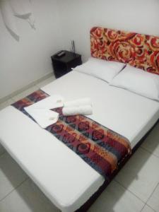 伊瓦格montecarlos hotel的一张白色的床,上面有一条毯子