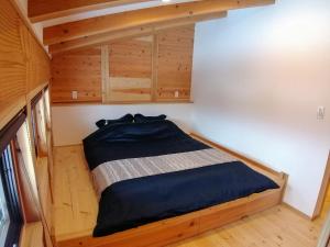 饭山市Tombi Lodge的一间小卧室,小房子里配有一张床