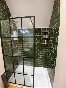 巴斯Enchanted Hideaway, Bath的带淋浴的浴室和绿色瓷砖墙壁