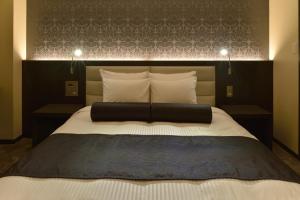 松山ANA Crowne Plaza Matsuyama, an IHG Hotel的一间卧室配有一张大床和黑色床头板