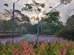 尖竹汶绿色双度假村的一座种满五颜六色花卉的公园和一座池塘