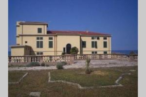 卡斯塔涅托卡尔杜奇APPARTAMENTO IN VILLA STORICA SUL MARE PER 8/10 PERSONE的前面有围栏的大房子