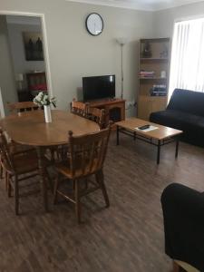 诺拉灰色鹅卵石公寓的客厅配有桌子和沙发