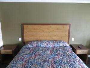 安纳海姆加登格罗夫国家旅馆的一间卧室配有一张床、两个床头柜和两张桌子