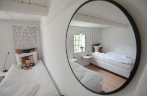图默利拉4B Österlen Bed & Breakfast的卧室的镜子反射,配有两张床