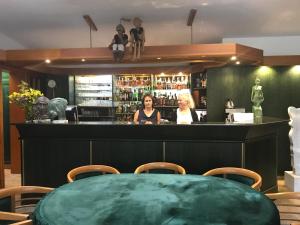 利托米什尔安提科索菲亚酒店的两名妇女站在一家餐馆的酒吧