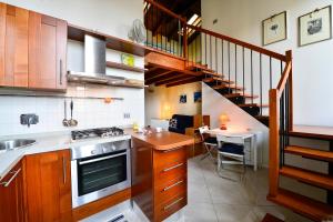 博洛尼亚UR-NEST Beverara的一个带木制橱柜的厨房和一个带桌子的楼梯