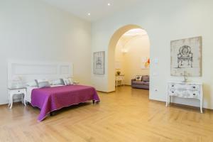 那不勒斯La Gatta Cenerentola Rooms的一间卧室配有一张带紫色毯子的床