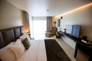 帕拉马里博Tucan Resort & Spa的酒店客房,配有床和电视
