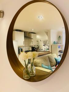 伦敦Stunning, peaceful entire flat in the centre of Wimbledon的带沙发和镜子的客厅