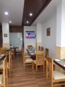 达纳尔蒂Himalayan Splendour Resort的一间带桌椅和电视的用餐室