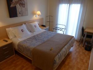 帕斯底拉卡萨Hotel Les Truites Adults only的一间卧室配有一张床、一张桌子和一个窗户。