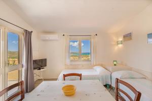 圣特奥多罗鲁尼巴黑度酒店的客房设有两张床、一张桌子和一扇窗户。