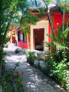玛丽亚法里尼亚Okakoaras Hotel的一座红白色房子,前面有棕榈树