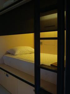 库塔Bali Caps Hostel by Xhosteller的卧室配有带白色床单的双层床