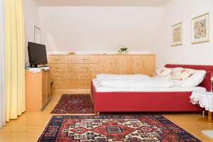 格拉茨普兰克酒店的一间设有床铺、电视和地毯的房间