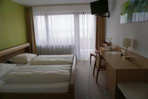 厄斯特里希-温克尔RUTHMANN-Rheinblick GARNI的酒店客房配有两张床和一张书桌