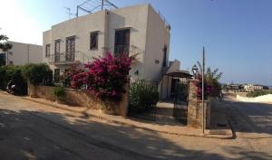 圣维托罗卡波Casa Vacanza Azzurra的街道前方的白色房子,花粉红色