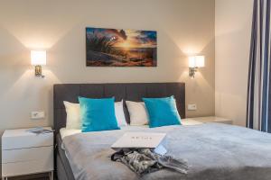 加兹尤瑟多姆Terrassenwohnung "Kliffgarten" - Oase am Haff的一间卧室配有一张带蓝色枕头的大床
