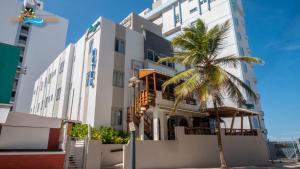 圣胡安沙滩酒店的前面有棕榈树的建筑