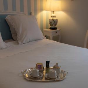 达克斯La Croix Blanche的床上的盘子,上面有杯子和碟子