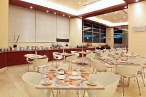 托卢卡Hotel Opus Grand Toluca Aeropuerto的一间带桌椅的用餐室和一间厨房