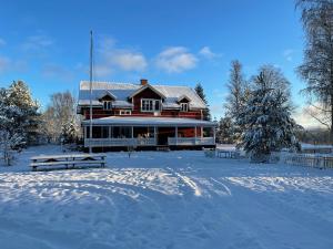 EkshäradAnneberg Guesthouse的前面有雪盖的大房子