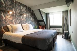 德科克斯多普Hotel het Anker van Texel的一间卧室配有一张带花卉壁纸的大床