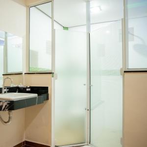 坎皮纳斯Prime Motel Campinas的一个带水槽的玻璃淋浴间