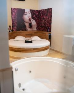 坎皮纳斯Prime Motel Campinas的带浴缸的浴室和一张女人的照片