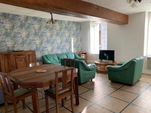 布里阿尔Gites de la Thiau的客厅配有桌椅和电视。