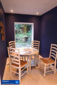 温什科姆Boutique cottage in the heart of Winchcombe的一间配备有白色桌椅的用餐室