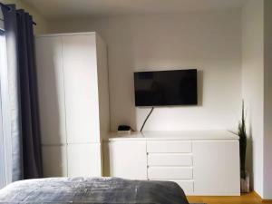 维也纳Cosy Park Apartment City Center的卧室配有白色梳妆台,墙上配有电视