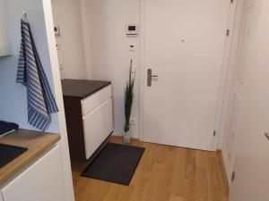 维也纳Cosy Park Apartment City Center的厨房设有白色的门,铺有木地板