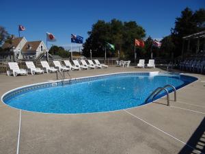 丹尼斯港乔纳森爱德华兹汽车旅馆的一个带椅子和旗帜的大型游泳池