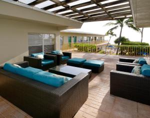 劳德代尔堡Tropic Seas Resort的天井配有沙发、椅子和桌子