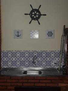 圣保罗CONDOMÍNIO ILHAS DO JUQUEHY的厨房柜台设有水槽和墙上的时钟