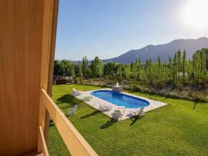 门多萨Cabañas Alpinas的享有带游泳池和椅子的庭院的景色