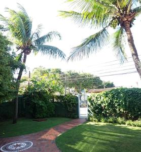 里约达欧特拉斯Pousada Bartrô的一座花园,两棵棕榈树和一个砖砌的走道