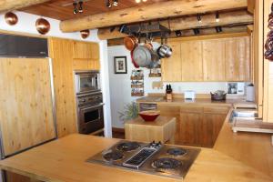 杰克逊斯普林克里克牧场酒店的厨房配有木制橱柜和炉灶烤箱。