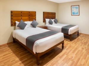 韦拉克鲁斯Collection O Hotel Mocambo, Boca del Río的铺有木地板的客房内的两张床
