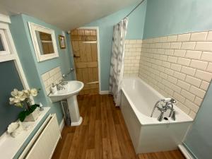 科尔切斯特Prince Cottage的带浴缸和盥洗盆的浴室