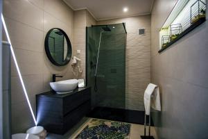 纳扎雷Préstige Holidays Alojamentos的浴室配有盥洗盆和带镜子的淋浴