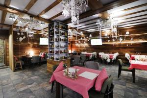 别洛库里哈Spa Resort Kedroviy的用餐室配有粉红色的桌椅和吊灯。