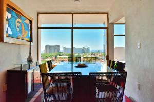 巴亚尔塔港Hotel Blue Home Vallarta的一间带桌椅和大窗户的用餐室