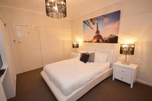 伊丘卡No.40 Echuca - Echuca Holiday Homes的一间卧室配有一张白色的床,享有艾菲尔铁塔的景色。