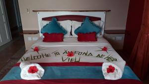 安塞罗亚莱欧丰德梅尔景致酒店的一张带红色和蓝色枕头的床,上面有标志