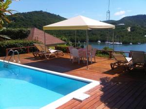 英吉利港安提瓜海洋酒店的一个带桌子和遮阳伞的甲板和一个游泳池