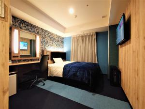宫崎Green Rich Hotel Miyazaki Tachibandori 2 (Artificial hot spring Futamata Yunohana)的配有一张床和一台平面电视的酒店客房