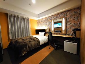 宫崎Green Rich Hotel Miyazaki Tachibandori 2 (Artificial hot spring Futamata Yunohana)的酒店客房带一张床、一张书桌和一面镜子